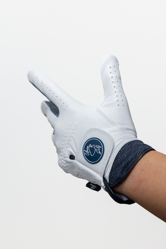 Close-up of the Alpine Golf Nami Edition glove, highlighting the premium white Cabretta leather palm and the signature navy Japanese wave pattern on the moisture-wicking cuff.