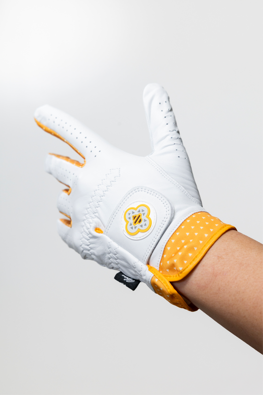 Macro shot of the Alpine Golf Raiu edition glove, showcasing the premium white AAA Cabretta leather texture and the custom electric yellow lightning pattern on the moisture-wicking athletic cuff.
