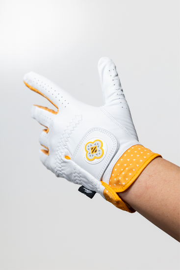 Macro shot of the Alpine Golf Raiu edition glove, showcasing the premium white AAA Cabretta leather texture and the custom electric yellow lightning pattern on the moisture-wicking athletic cuff.